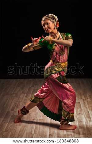 Young beautiful woman dancer exponent of Indian classical dance Bharatanatyam in Krishna pose