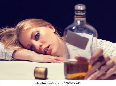 Young beautiful woman in depression, drinking alcohol