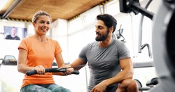 Woman exercising in gym personal trainer plan on clipboard