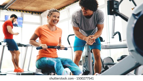 Young beautiful woman doing exercises with personal trainer - Powered by Shutterstock