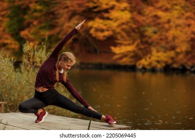 A young beautiful woman is doing exercises in the autumn forest