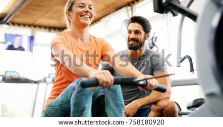 Young beautiful woman doing exercises with personal trainer