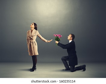young beautiful woman don't looking at man with flowers