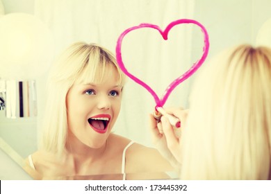 Young Beautiful Woman Drawing Big Heart On Mirror In Bathroom.