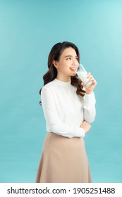 Young Beautiful Woman Drink A Glass Of Milk On Blue Background