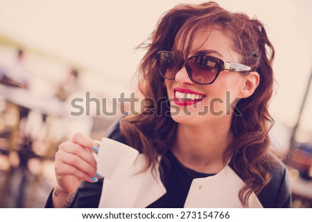 Young beautiful woman drinking coffe at cafe
