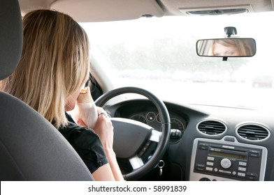 Young Beautiful Woman Driving Car And Eating Fast Food - Rear View