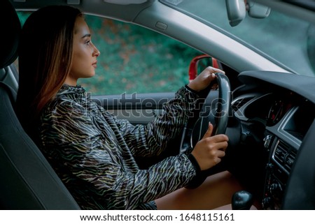 Young beautiful woman driving her new car