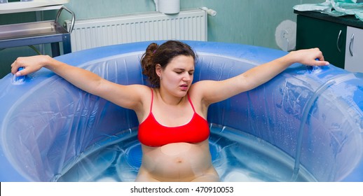 Young Beautiful Woman During Labour Right Before Giving Birth In Water.