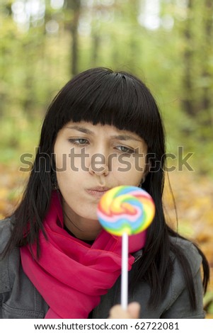 Young beautiful woman eating candy
