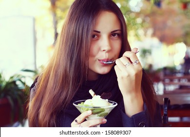 Young Beautiful Woman Eating A Dessert Of Kiwi