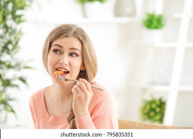 Young beautiful woman eating fresh salad on blurred background - Shutterstock ID 795835351