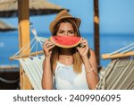 Young beautiful woman eating juicy watermelon on the beach.