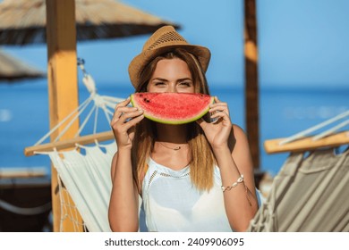 Young beautiful woman eating juicy watermelon on the beach. - Powered by Shutterstock