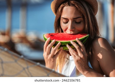 Young beautiful woman eating juicy watermelon on the beach. - Powered by Shutterstock