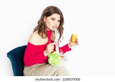 Young Beautiful Woman Eating A Plastic Bag As A Concept Of Plastic Contaminated Food. Ecology And Healthy Eating Concept. Studio Shot.. Hight Quality Photo