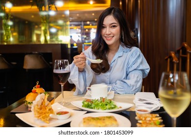 young beautiful woman eating in the restaurant - Powered by Shutterstock