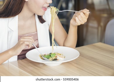 Young Beautiful Woman Eating Spaghetti Or Pasta During A Lunch Time, Feeling Yummy Or Delicious And Happiness. Many Person Likes Italian Food. - Happiness Concept
