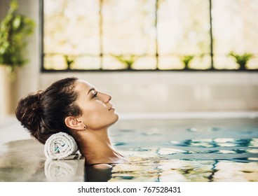 Young Beautiful Woman Enjoying Summer Holiday In Swimming Pool At Resort Hotel. Girl Relaxing At Hotel. Spa, Retreat, Relaxation Concept. Beauty And Body Care