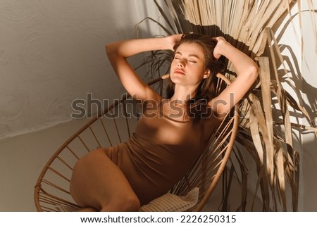 Young beautiful woman enjoys the sun rays at home in the bathroom. Preparation for taking a bath.