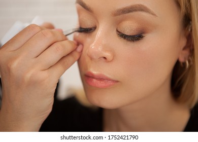 Young Beautiful Woman Getting False Lashes Applied By Professional Makeup Artist