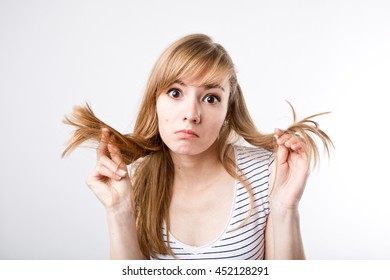 Young beautiful woman  girl pulling her long light hair 