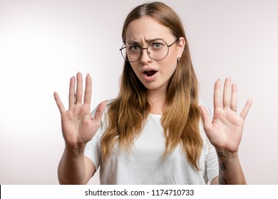 Young beautiful woman in glasses making the hand stop sign, isolated on the white background. close up photo. calm down, please. Don't worry - Shutterstock ID 1174710733