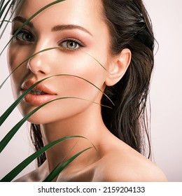 Young Beautiful Woman With Green Leaves Near Face. Skin Care Beauty Treatments Concept.  Closeup Girl's Face With Green Leave. White Model With Clean, Health Skin Of Face - Posing At Studio