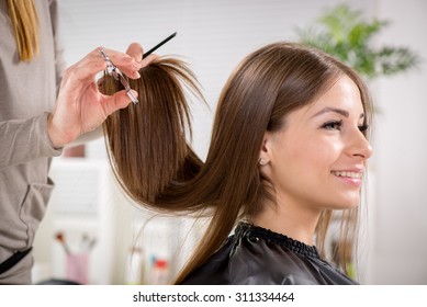 Young Beautiful Woman Having Her Hair Cut At The Hairdresser's.