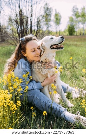 Young beautiful woman and her golden retriever dog having fun in summer