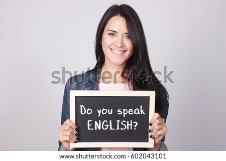 Young beautiful woman holding a chalkboard that says Do You Speak English? 