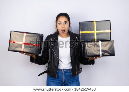Young beautiful woman holding gifts over isolated white background scared in shock with a surprise face, afraid and excited with fear expression