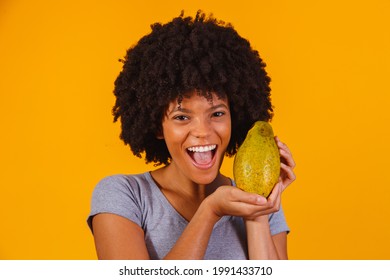 Young Beautiful Woman Holding Papaya Over Yellow Isolated Background