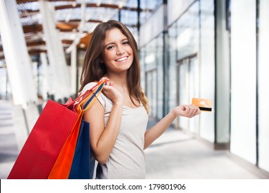 Young Beautiful Woman Holding Shopping Bags And A Credit Card