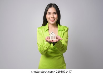 A Young Beautiful Woman Holding Small Model House Over White Background Studio	
