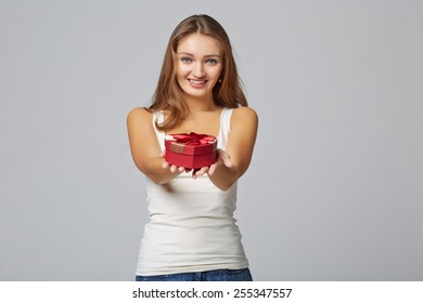 Young Beautiful Woman Holding Small Red Box. Studio Portrait On Gray Background