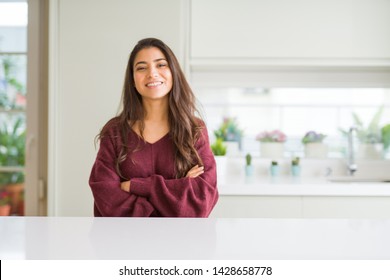Young beautiful woman at home happy face smiling with crossed arms looking at the camera. Positive person.
