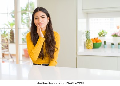 Young Beautiful Woman At Home On White Table Touching Mouth With Hand With Painful Expression Because Of Toothache Or Dental Illness On Teeth. Dentist Concept.