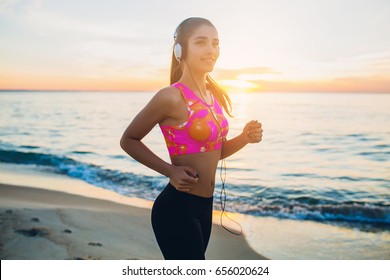 Young Beautiful Woman Jogging On Beach, Morning, Fitness Outfit, Listening To Music On Headphones, Sea Sunrise, Skinny Perfect Slim Body, Healthy Living Lifestyle, Summer, Smiling, Happy