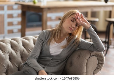 Young Beautiful Woman Lay Down On The Sofa At Home, Suffering From Headache