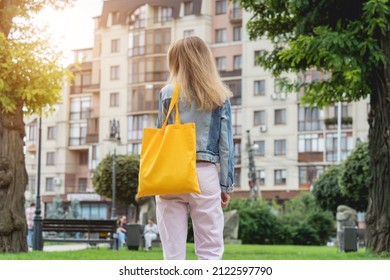Young beautiful woman with linen eco bag on city background.
