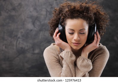 Young Beautiful Woman Listening To Music With Headphones