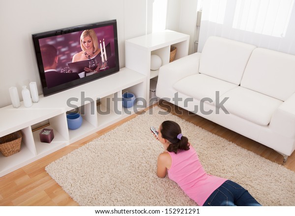 Young\
Beautiful Woman In Living Room Watching\
Television
