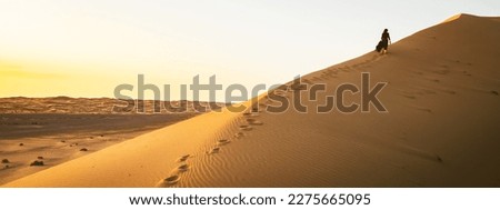 Young beautiful woman in long dress walks along sand dunes in iran KAshan desert