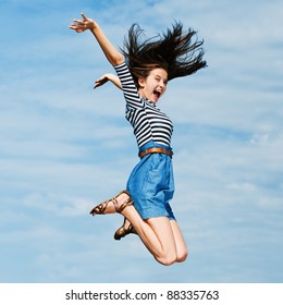 young beautiful woman with long hair on a summer day in the meadow jumping high