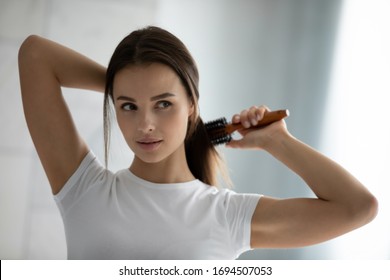 Young Beautiful Woman Look In Mirror Brush Long Healthy Brunette Hair, Millennial Female Do Morning Beauty Routine In Bathroom Experiment With Hairstyle, Restoration Mask, Haircare Concept