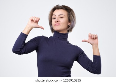 Young beautiful woman looking confident with smile on face, pointing herself with fingers being proud and happy.