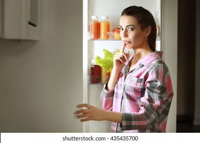 Young Beautiful Woman Looking Into Fridge At Night