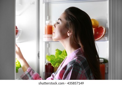 Young Beautiful Woman Looking Into Fridge At Night