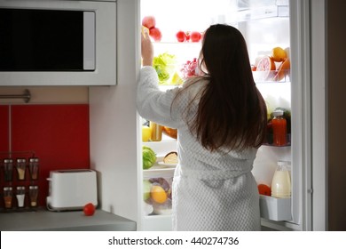 Young Beautiful Woman Looking Into Fridge At Night